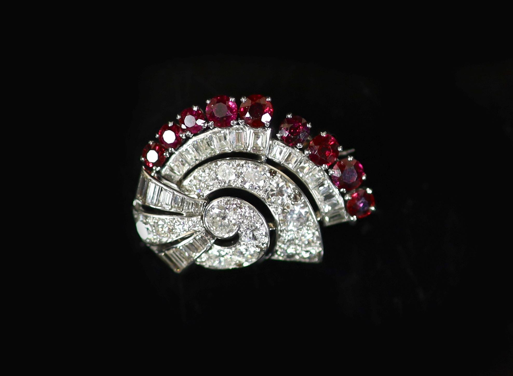 A mid 20th century white gold, ruby and diamond set fan shaped scroll brooch